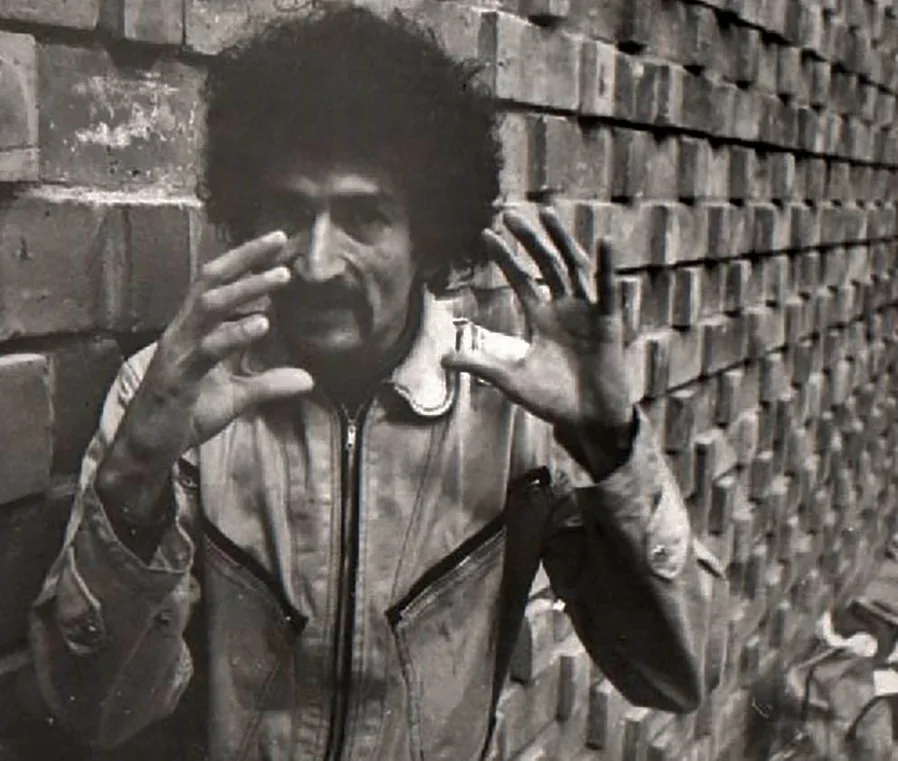 Eddy Armando Rodríguez gesticulando frente a un muro de ladrillo